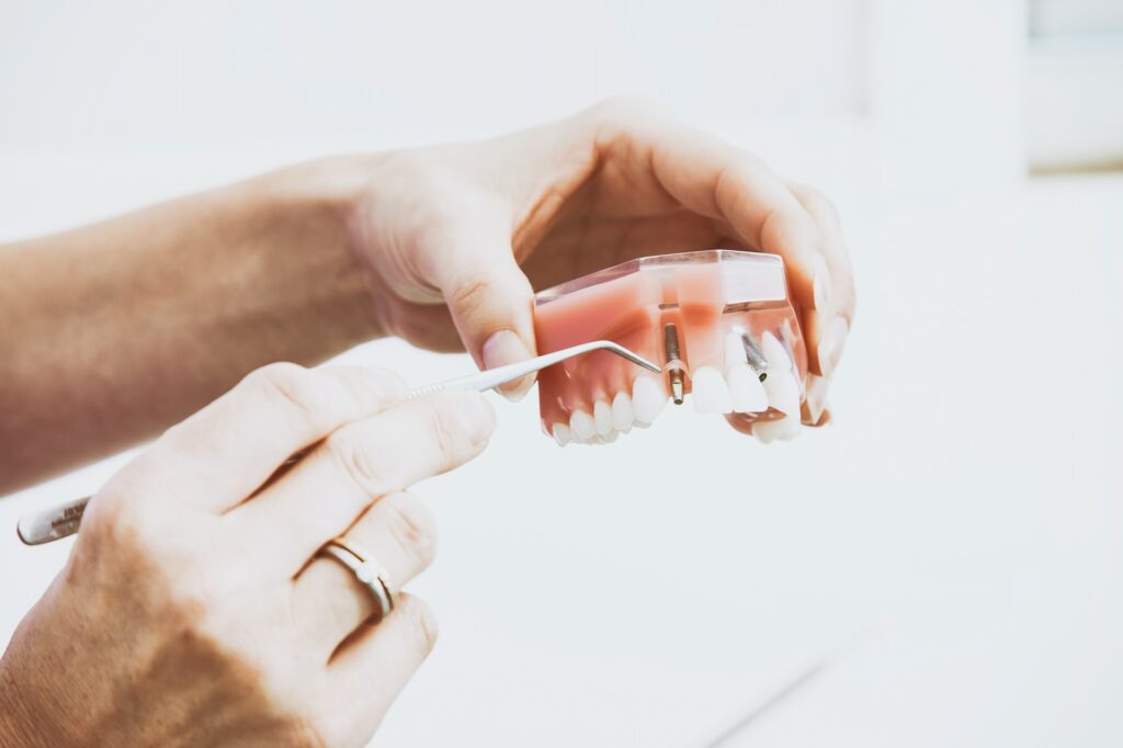 A dental hygienist uses a dental tool to indicate the placement of the dental implants